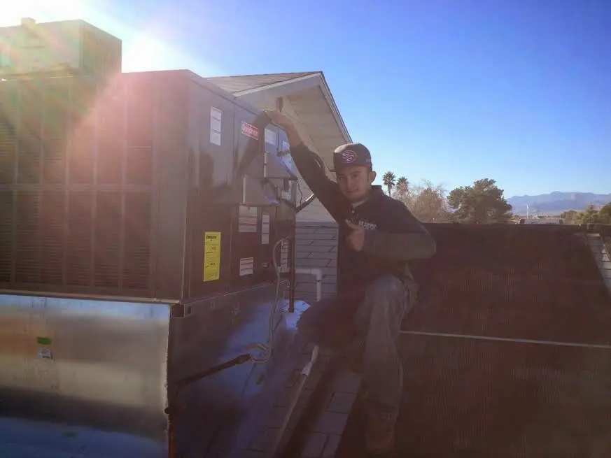 HVAC technician performing HVAC Inspection on a rooftop unit in Beacon Falls